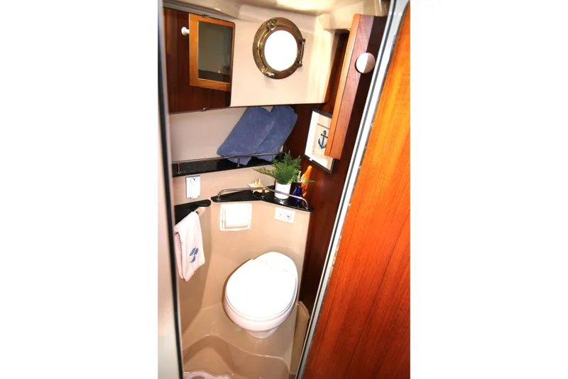 Slide: The Image of Compact bathroom in 2013 Ranger Tugs R-31 CB boat with porthole and wooden cabinetry. - 26