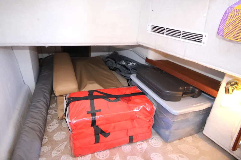 Slide: The Image of Storage area in 2013 Ranger Tugs R-31 CB with life jackets and containers. - 27