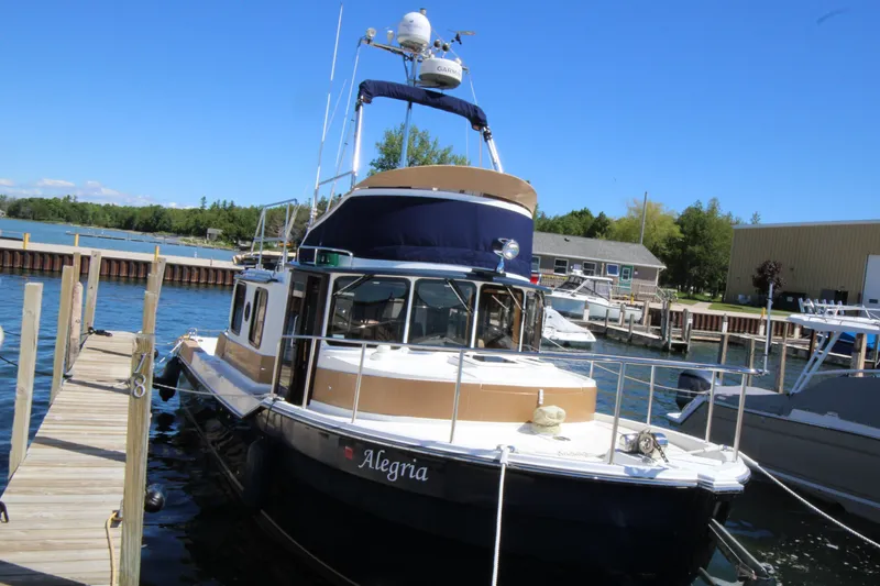 Slide: The Image of 2013 Ranger Tugs R-31 CB docked at marina under clear blue sky. - 3