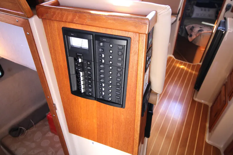 Slide: The Image of Electrical panel inside 2013 Ranger Tugs R-31 CB boat, featuring wooden interior and striped flooring. - 30