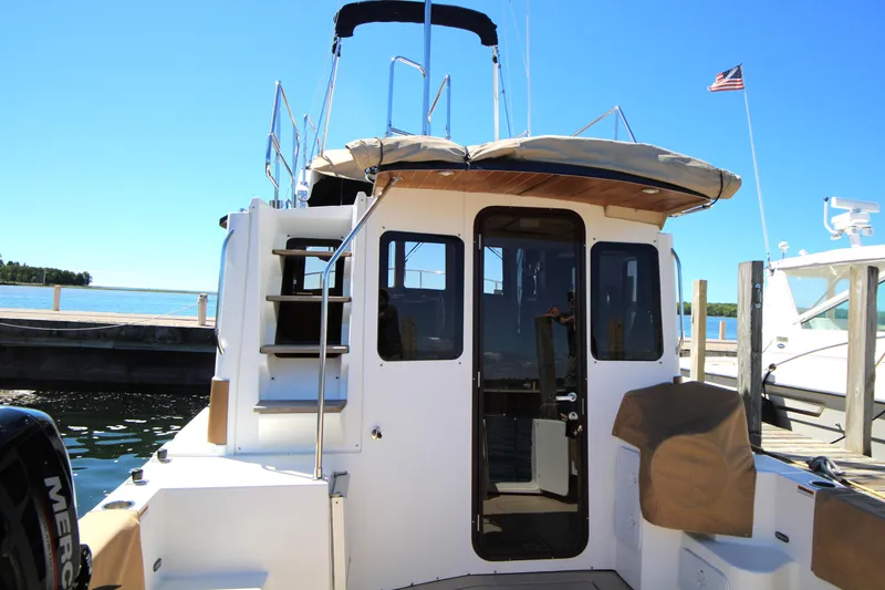 Slide: The Image of 2013 Ranger Tugs R-31 CB docked, rear view with stairs and American flag. - 6