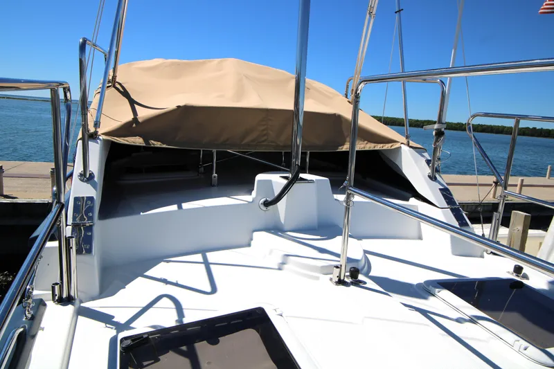 Slide: The Image of 2013 Ranger Tugs R-31 CB boat deck with tan cover, docked by the water. - 7