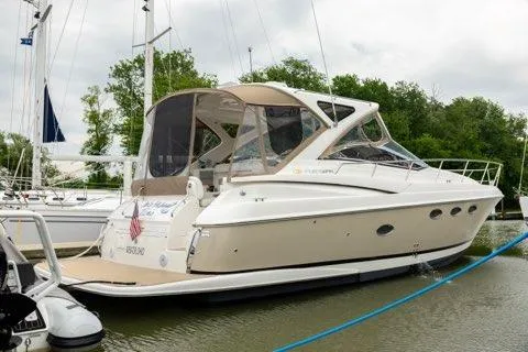 The Image of 2008 Regal Commodore 3860 yacht docked in a marina, surrounded by trees and other boats. - 1