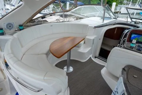 Slide: The Image of 2008 Regal Commodore 3860 yacht interior with white seating and wooden table. - 3