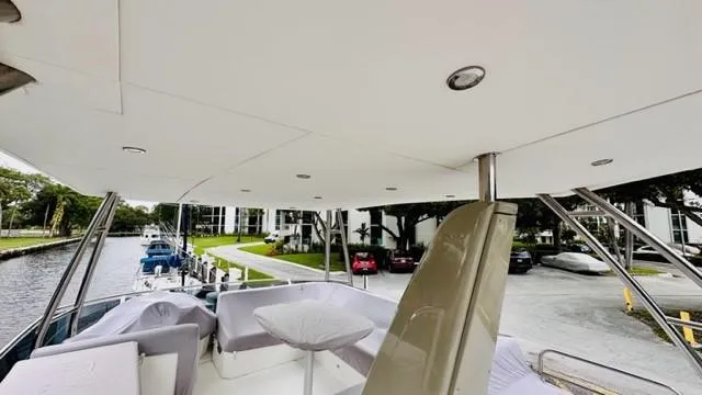 Slide: The Image of Flybridge view of 2022 Greenline 48 with hardtop, docked near waterfront. - 22