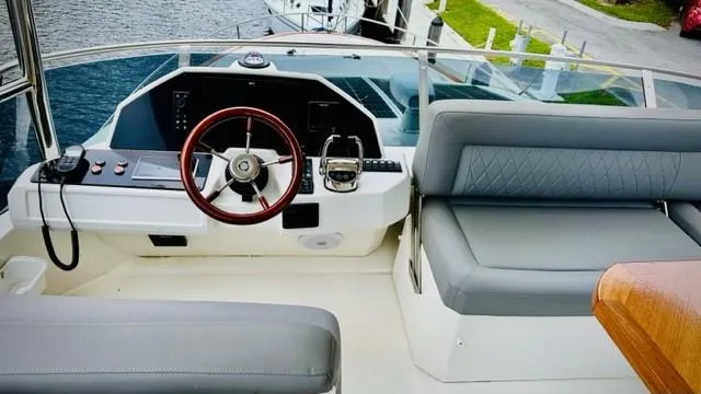 Slide: The Image of Flybridge helm of 2022 Greenline 48 with Hardtop, featuring modern controls and seating. - 24