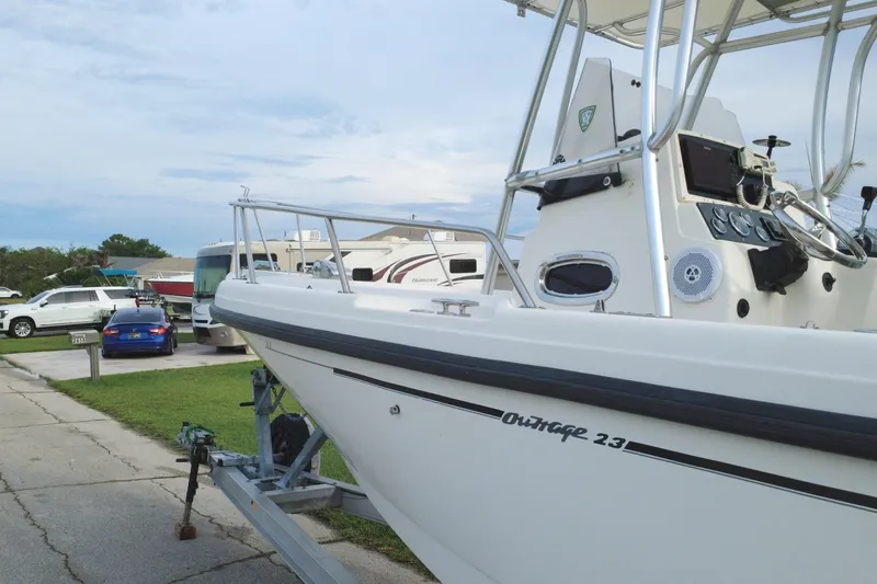 Slide: The Image of 1998 Boston Whaler 230 Outrage boat on trailer, parked near RVs and cars. - 18