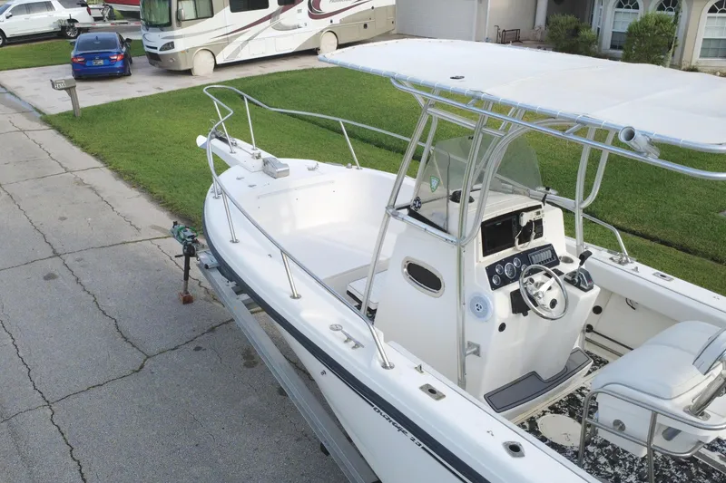 Slide: The Image of 1998 Boston Whaler 230 Outrage boat parked on a residential street. - 19