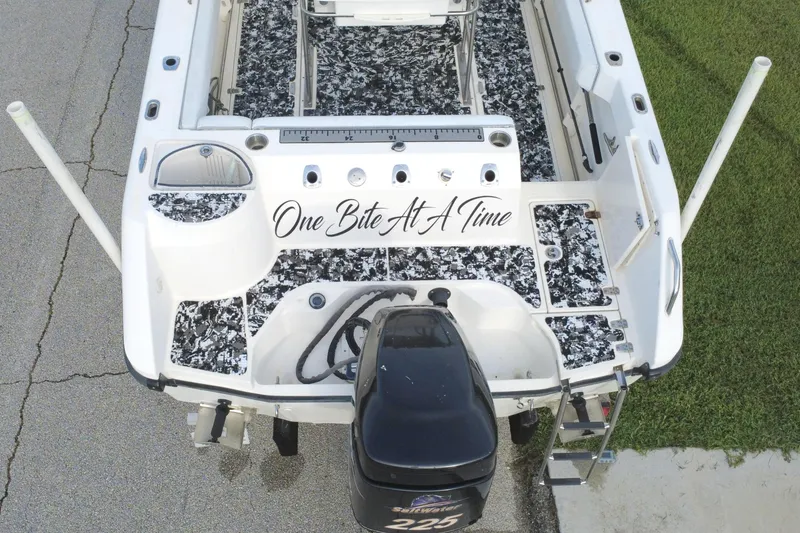 Slide: The Image of 1998 Boston Whaler 230 Outrage boat with custom flooring and "One Bite At A Time" text. - 21