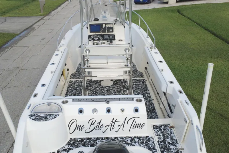 Slide: The Image of 1998 Boston Whaler 230 Outrage boat with custom flooring and "One Bite At A Time" text. - 22