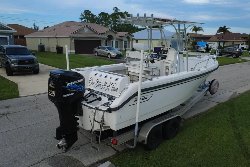 Slide: The Image of 1998 Boston Whaler 230 Outrage boat on trailer, parked in residential area. - 28