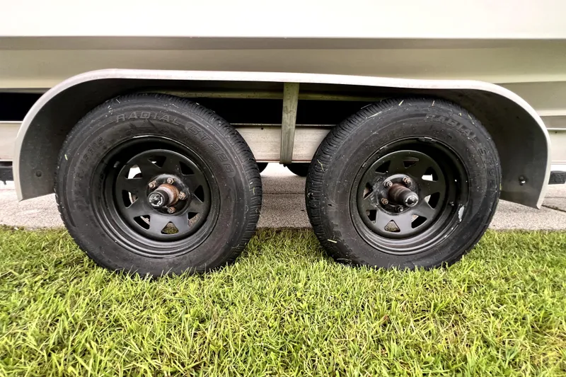 Slide: The Image of Trailer wheels of a 1998 Boston Whaler 230 Outrage on grass. - 30