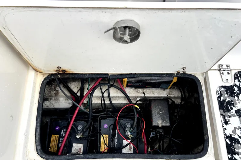 Slide: The Image of Battery compartment of a 1998 Boston Whaler 230 Outrage with visible wiring and charger. - 33