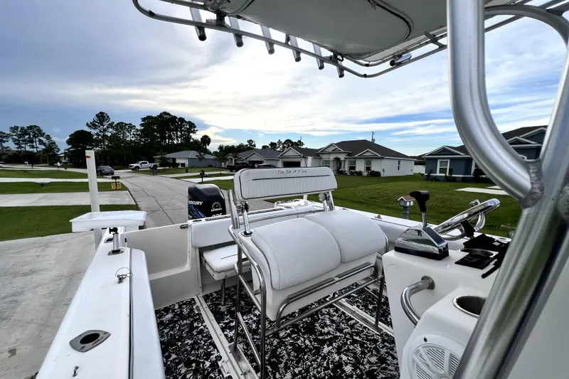 Slide: The Image of 1998 Boston Whaler 230 Outrage boat interior with seating and controls, parked in a residential area. - 37