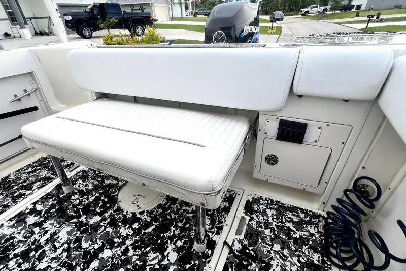 Slide: The Image of 1998 Boston Whaler 230 Outrage boat interior with white seating and patterned flooring. - 40