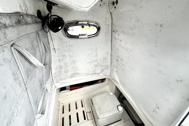 Slide: The Image of Interior cabin of a 1998 Boston Whaler 230 Outrage boat, featuring a small window. - 44