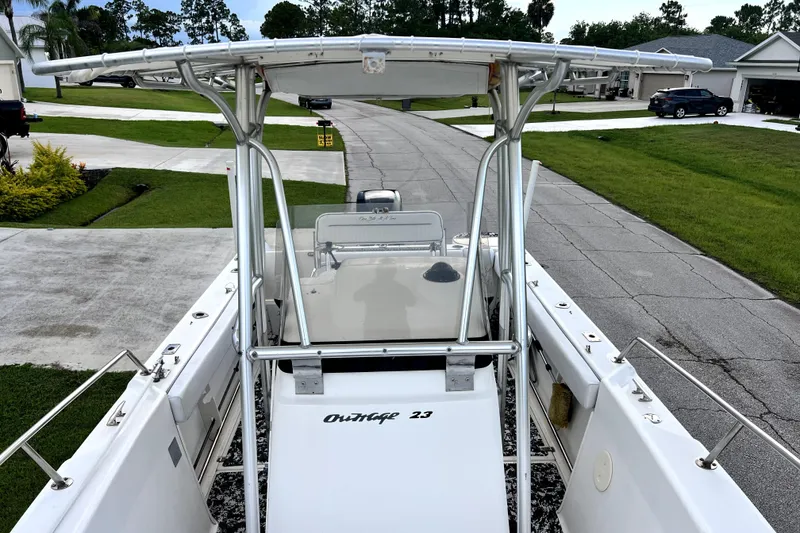 Slide: The Image of 1998 Boston Whaler 230 Outrage boat parked in a residential driveway. - 45