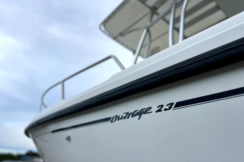 Slide: The Image of 1998 Boston Whaler 230 Outrage boat, close-up view of hull and railing. - 49