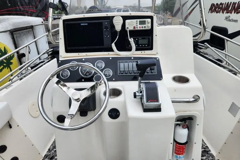 Slide: The Image of 1998 Boston Whaler 230 Outrage boat console with steering wheel and navigation equipment. - 5