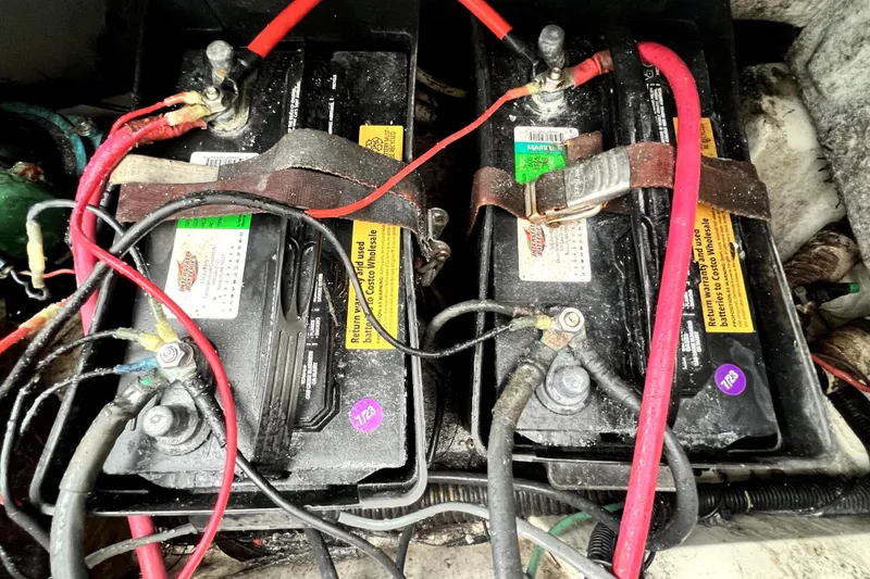 Slide: The Image of Two marine batteries with cables in a 1998 Boston Whaler 230 Outrage boat. - 55