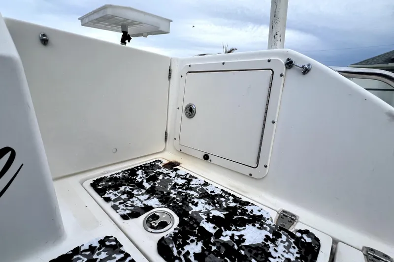Slide: The Image of 1998 Boston Whaler 230 Outrage boat interior, featuring storage compartment and textured flooring. - 58