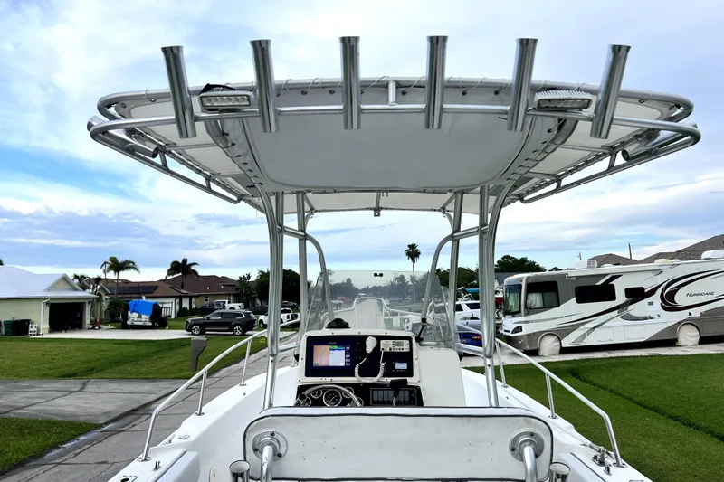 Slide: The Image of 1998 Boston Whaler 230 Outrage boat with T-top and navigation equipment, parked in a residential area. - 61