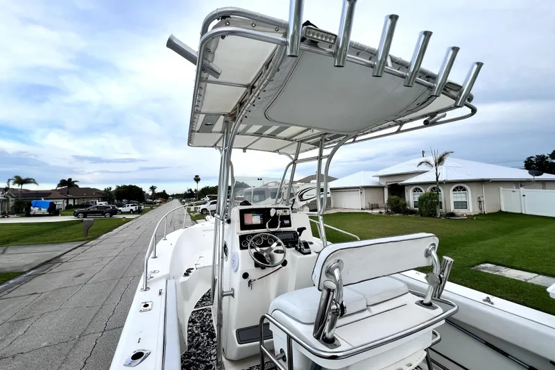 Slide: The Image of 1998 Boston Whaler 230 Outrage boat with T-top and console, parked in a residential area. - 62