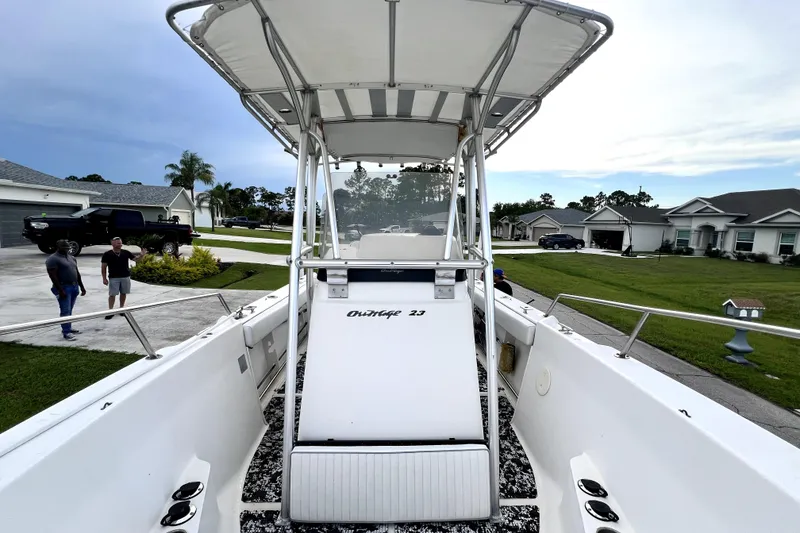 Slide: The Image of 1998 Boston Whaler 230 Outrage boat with T-top, parked in a residential driveway. - 69