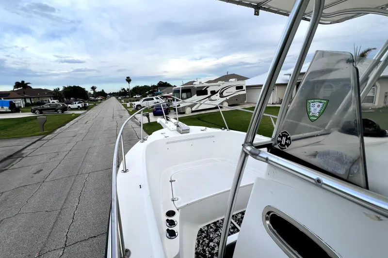 Slide: The Image of 1998 Boston Whaler 230 Outrage boat parked on a residential street. - 76