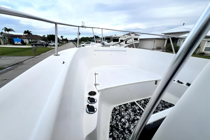 Slide: The Image of 1998 Boston Whaler 230 Outrage boat deck with railing, parked in residential area. - 77