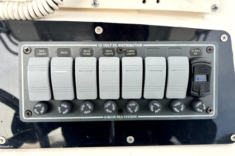 Slide: The Image of 1998 Boston Whaler 230 Outrage 12-volt DC distribution panel with labeled switches and fuses. - 83