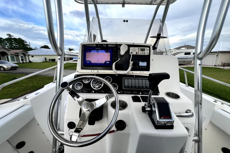Slide: The Image of 1998 Boston Whaler 230 Outrage boat console with steering wheel and navigation equipment. - 86
