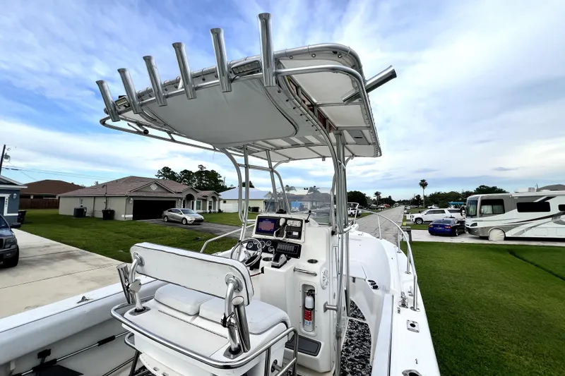 Slide: The Image of 1998 Boston Whaler 230 Outrage boat with T-top and console, parked in residential area. - 87