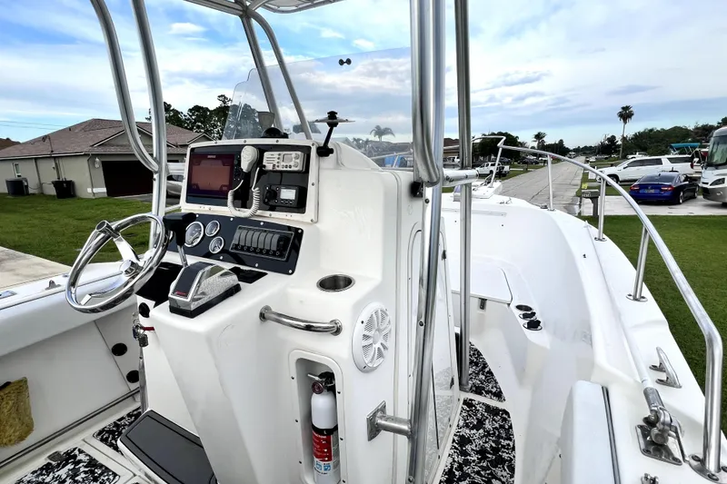 Slide: The Image of 1998 Boston Whaler 230 Outrage boat cockpit with steering wheel and navigation equipment. - 88