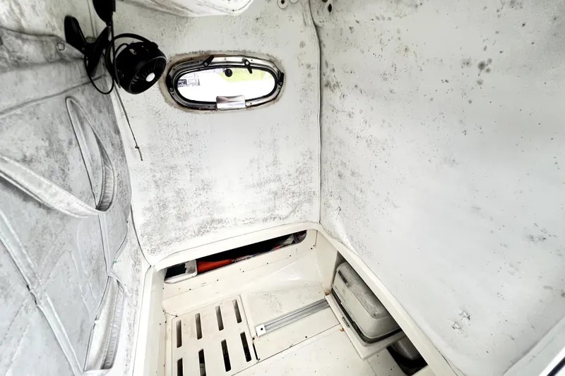 Slide: The Image of Interior cabin of a 1998 Boston Whaler 230 Outrage boat, showing wear and mold. - 90