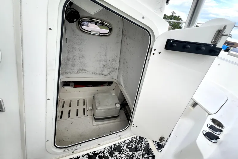 Slide: The Image of 1998 Boston Whaler 230 Outrage boat interior storage compartment with portable toilet. - 91