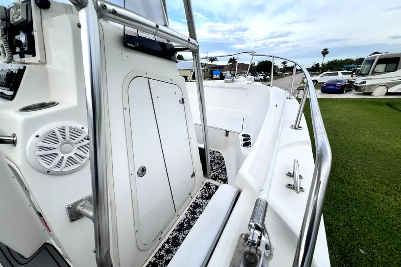 Slide: The Image of 1998 Boston Whaler 230 Outrage boat deck with railing and storage compartment. - 93