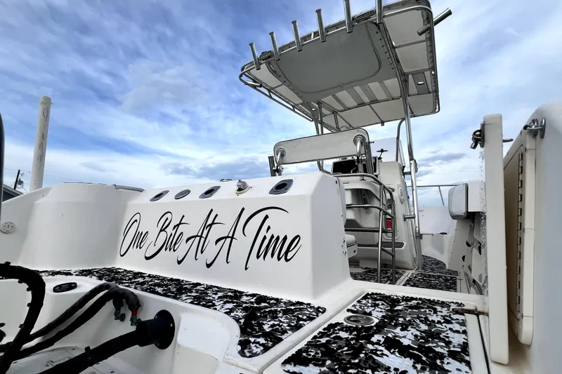 Slide: The Image of 1998 Boston Whaler 230 Outrage boat with "One Bite At A Time" text, under a cloudy sky. - 97