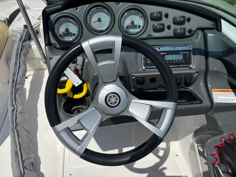 Slide: The Image of The image shows the helm of a 2014 Yamaha AR210 boat with instruments and controls. - 5