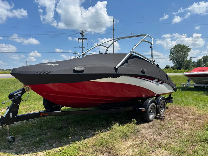 Slide: The Image of A 2014 Yamaha AR210 boat on a trailer, set on grass under a blue sky. - 7