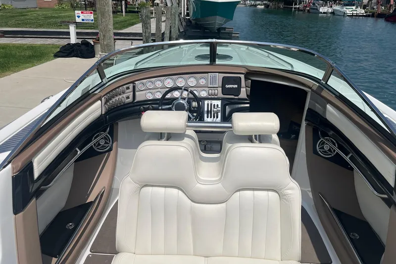 Slide: The Image of 2007 Cobalt 343 boat interior with white seating and detailed dashboard by the water. - 7