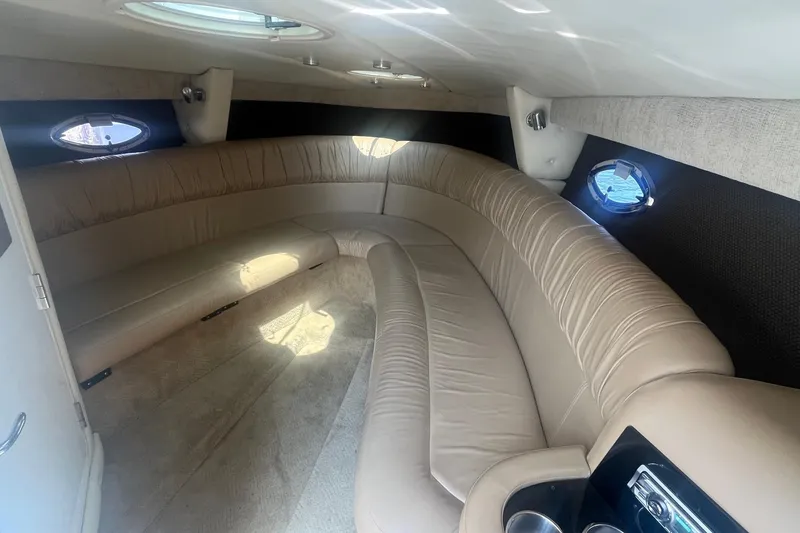 Slide: The Image of Luxurious interior of a 2007 Cobalt 343 boat with beige leather seating and porthole windows. - 20