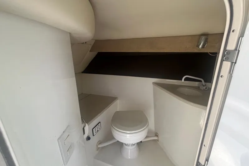 Slide: The Image of Compact bathroom inside a 2007 Cobalt 343 boat, featuring a toilet and small sink. - 22