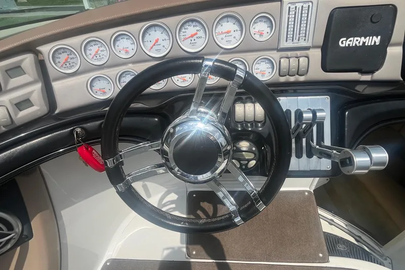 Slide: The Image of Steering wheel and dashboard of a 2007 Cobalt 343 boat with Garmin navigation. - 13