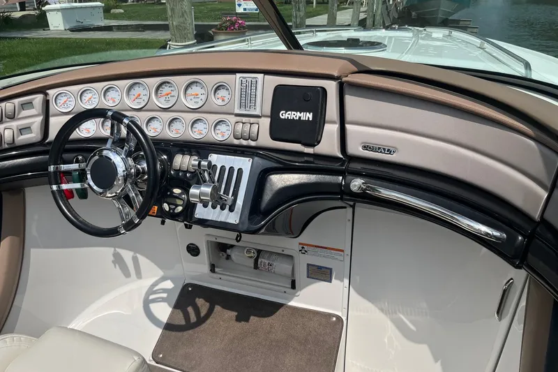 Slide: The Image of Dashboard of a 2007 Cobalt 343 boat with Garmin navigation system and multiple gauges. - 12