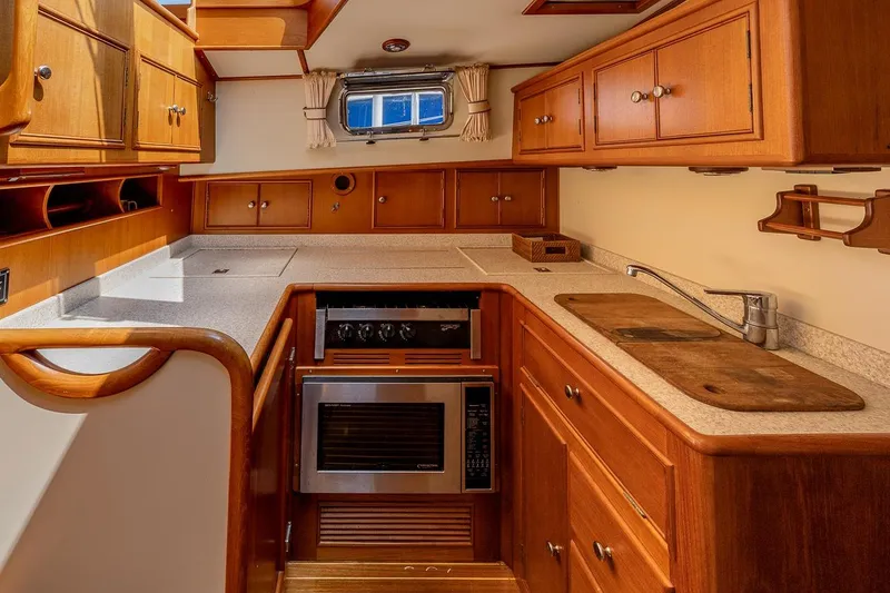 Slide: The Image of Galley with plenty of storage. H&C pressure water, refrigerator/freezer, microwave and stove. - 12