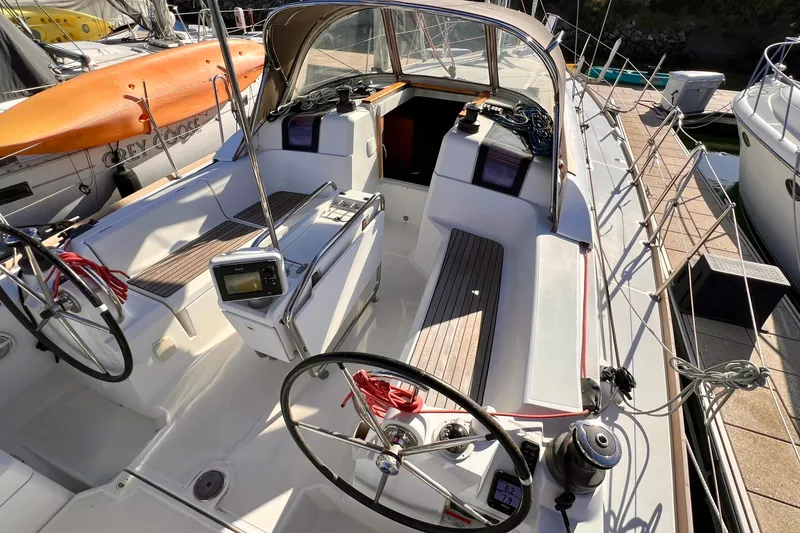 Slide: The Image of 2015 Jeanneau Sun Odyssey 379 sailboat cockpit with dual steering wheels and navigation equipment. - 13