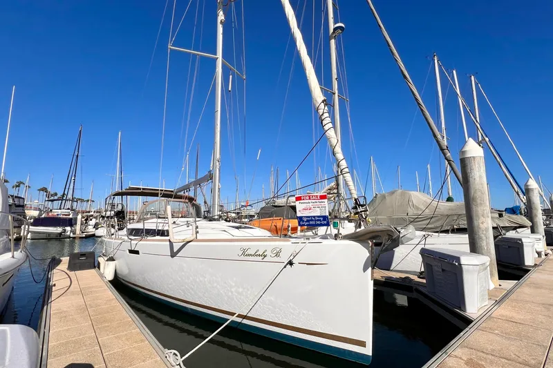 Slide: The Image of 2015 Jeanneau Sun Odyssey 379 sailboat docked, for sale, under clear blue sky. - 2