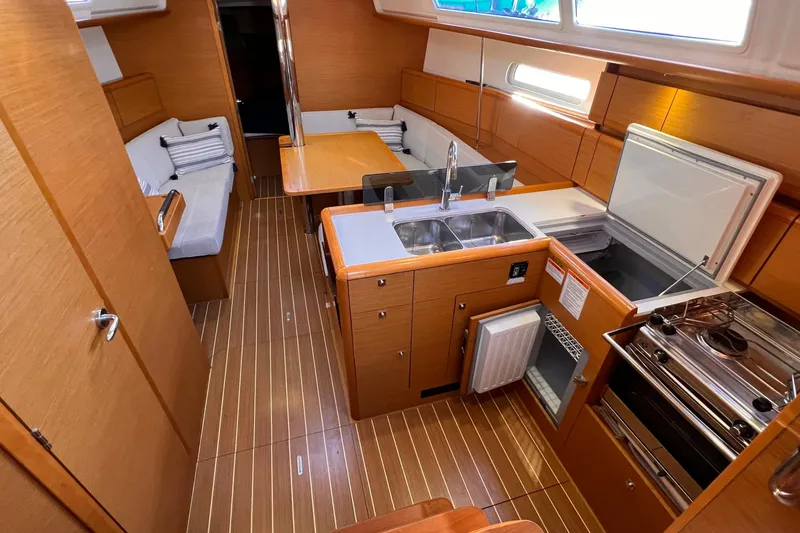 Slide: The Image of 2015 Jeanneau Sun Odyssey 379 interior with kitchen, dining area, and wooden flooring. - 31