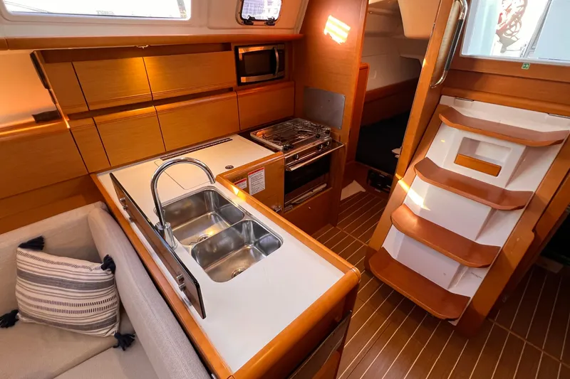 Slide: The Image of Interior of 2015 Jeanneau Sun Odyssey 379 sailboat, featuring a modern kitchen and cozy seating area. - 33